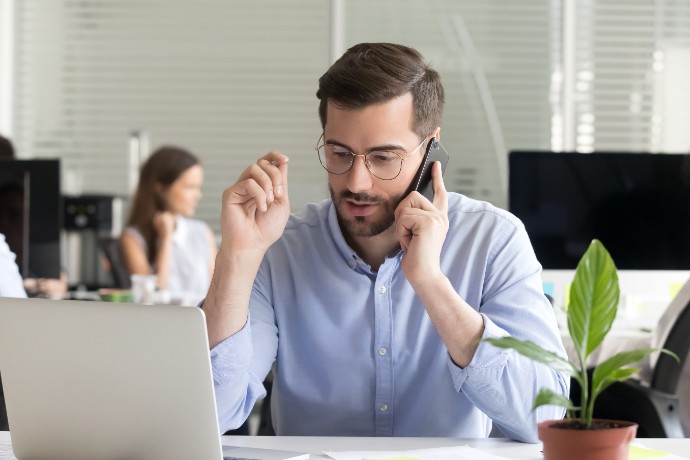 Marketing sales manager consulting client making offer selling talking on phone near laptop in office